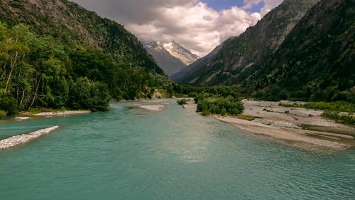Turquoise Mountain River and Clouds in Sky