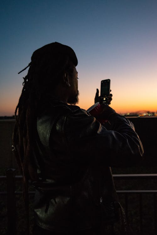 Free Man Leather Jacket Taking Photo of Sunset Stock Photo