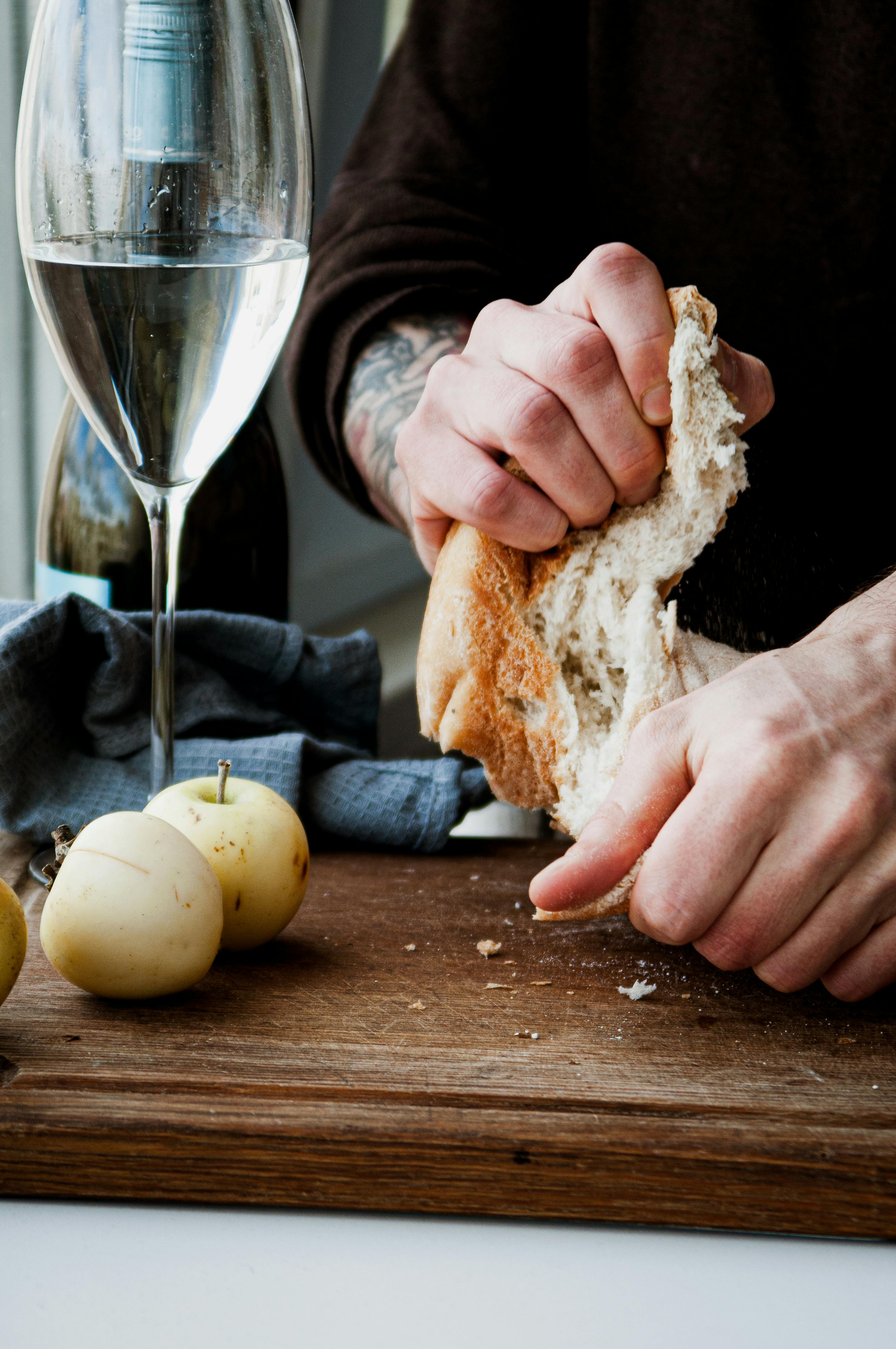 Hands Tearing Bread on Tray · Free Stock Photo