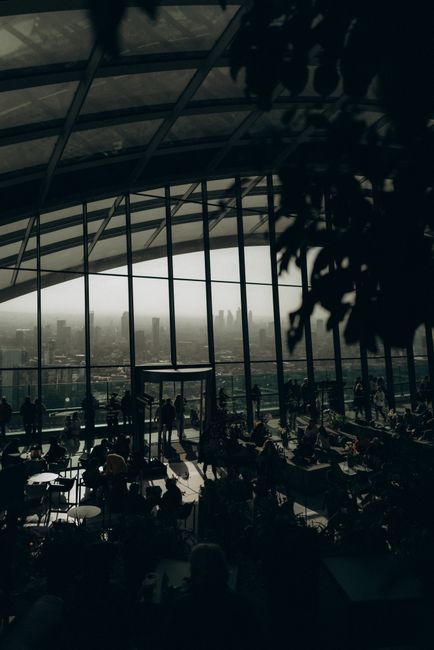 Modern indoor shot showing a cityscape through glass windows, blending architecture with urban life.