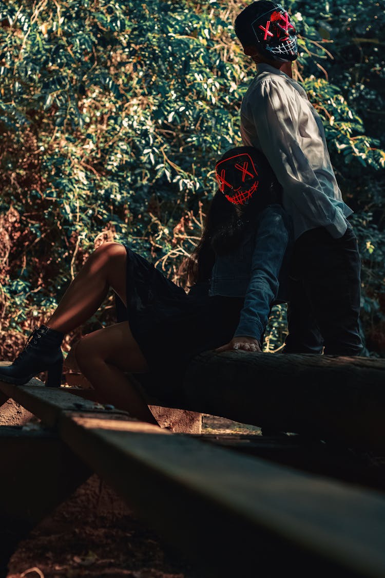 People In Masks Posing On Stairs Near Tree