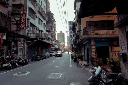 Vibrant urban street scene showcasing scooters and shops in an Asian cityscape.