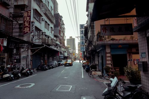 Free Vibrant urban street scene showcasing scooters and shops in an Asian cityscape. Stock Photo