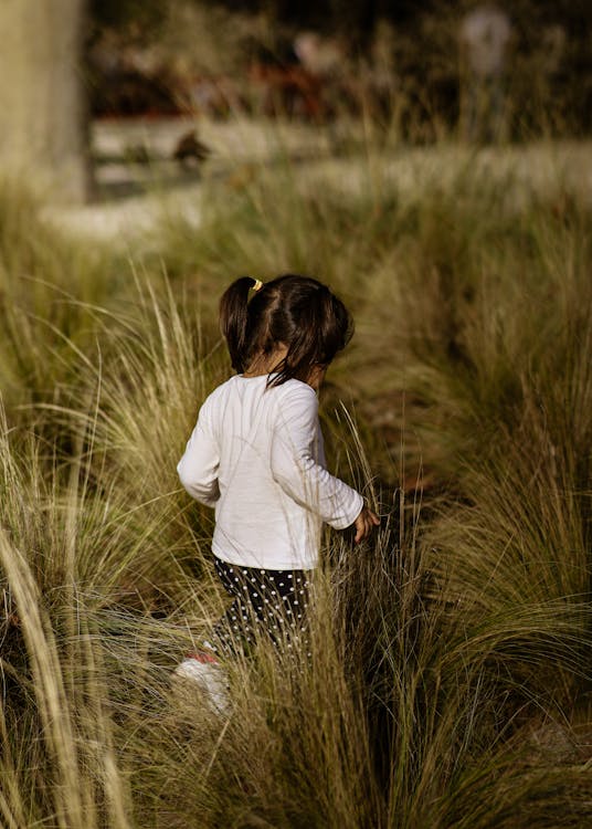 Photo of Girl Standing on Grassfield