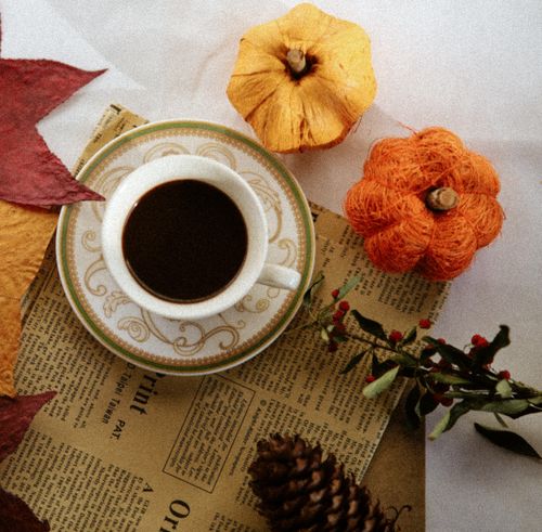 Free A cup of coffee on autumn leaves and decor, capturing warm seasonal vibes. Stock Photo