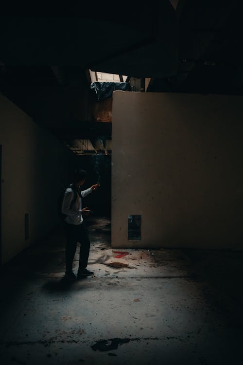 Man Smoking Cigarette in Dreary Building