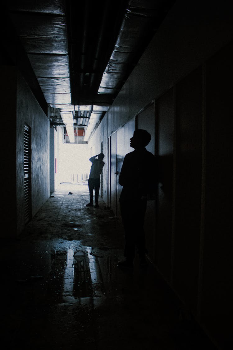 Dark Photo Of Two People In An Abandoned Hallway