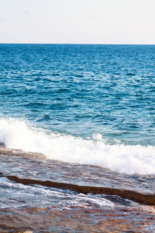 Free Beautiful ocean view with waves crashing on a rocky shore, depicting a serene coastal seascape. Stock Photo