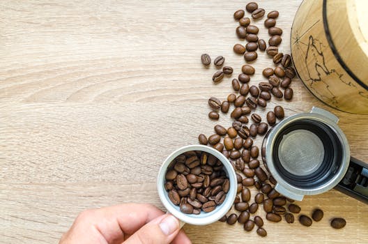 Flat lay of roasted coffee beans and portafilter on a wooden surface, showcasing coffee preparation.