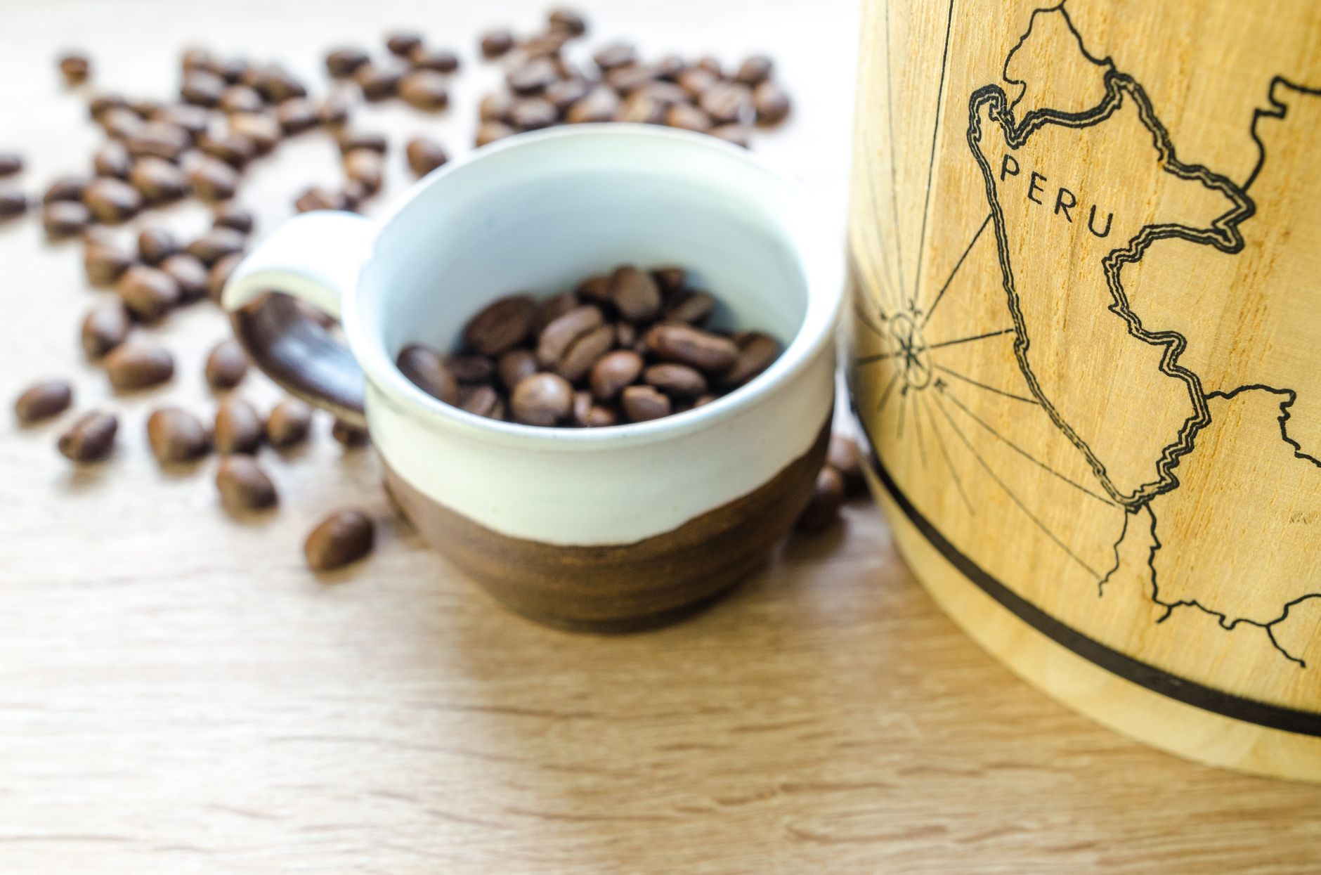 Close-up of fresh roasted coffee beans in a cup with a map of Peru. Perfect for café themes. What Is Single Origin Coffee?