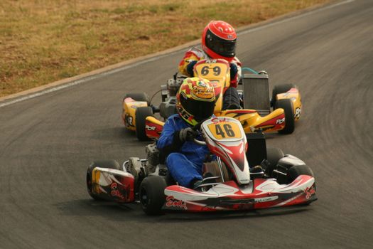 Racer Driving a Red Go Kart Leading the Race