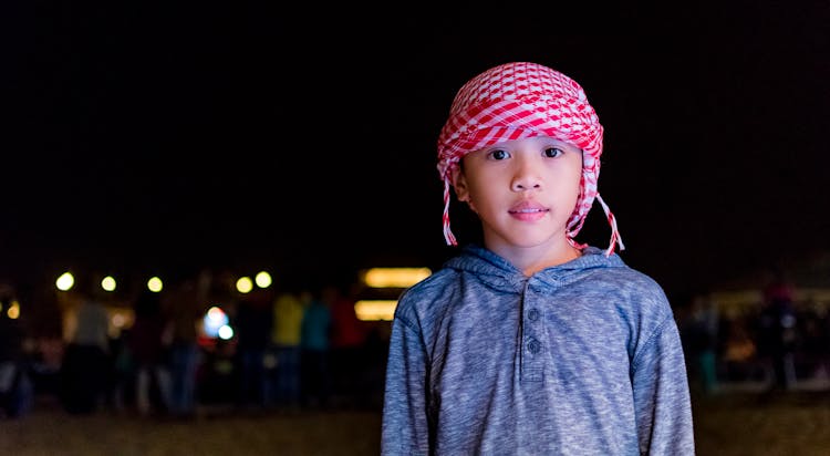 Portrait Of A Boy Wearing Red Arabic Scarf At Night