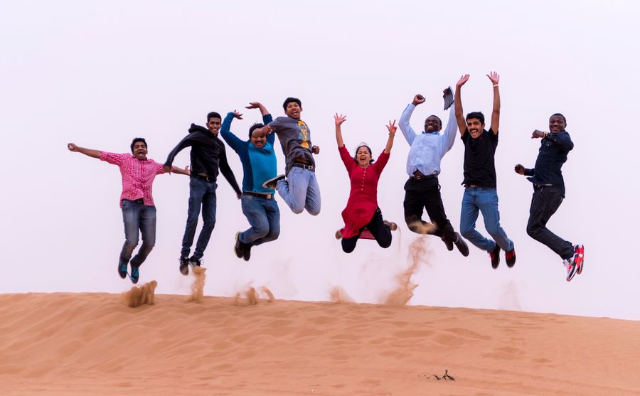 Calendar cover: a group jumping together on a sand dune — photo by Roderick Salatan on Pexels