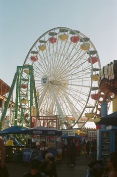 Capture the vibrant atmosphere at Santa Monica Pier with the iconic Ferris wheel and bustling crowd.