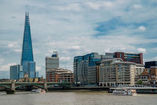 Free Explore London's skyline with The Shard towering over the Thames River and city buildings. Stock Photo