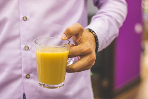 Personne Tenant Une Tasse Remplie De Jus