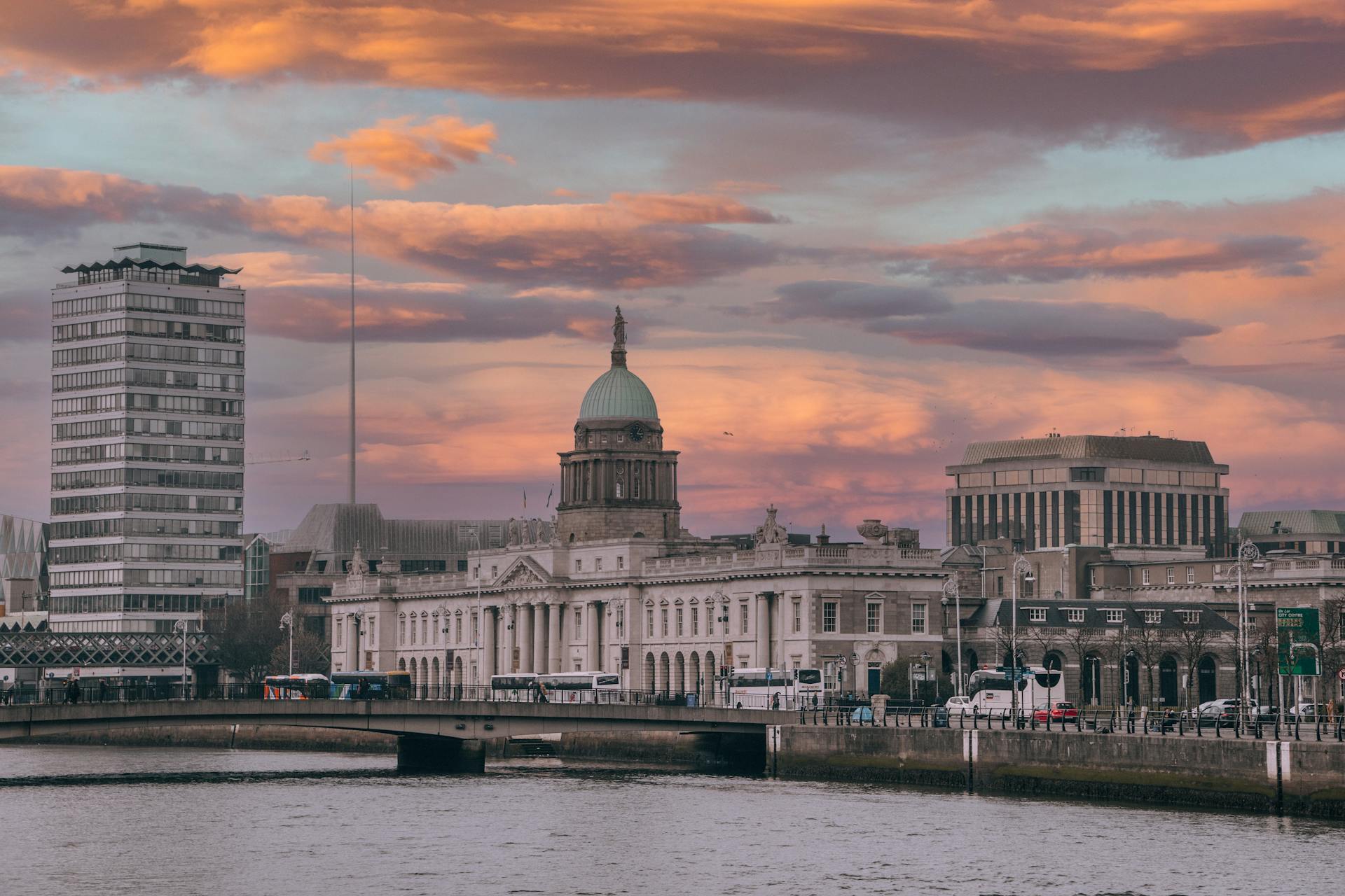 Stunning view of Dublin's Custom House and river at sunset, highlighting urban architecture.