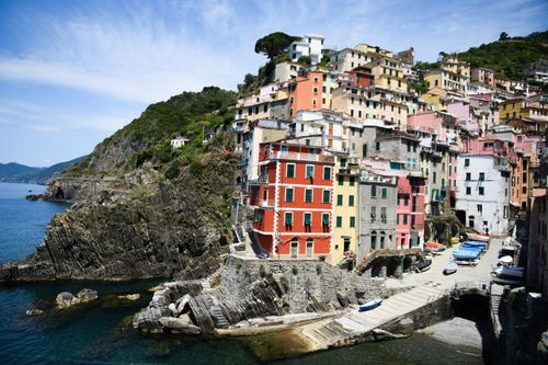 Free Colorful cliffside village of Riomaggiore, Italy, overlooking the azure Ligurian Sea, perfect for travel inspiration. Stock Photo