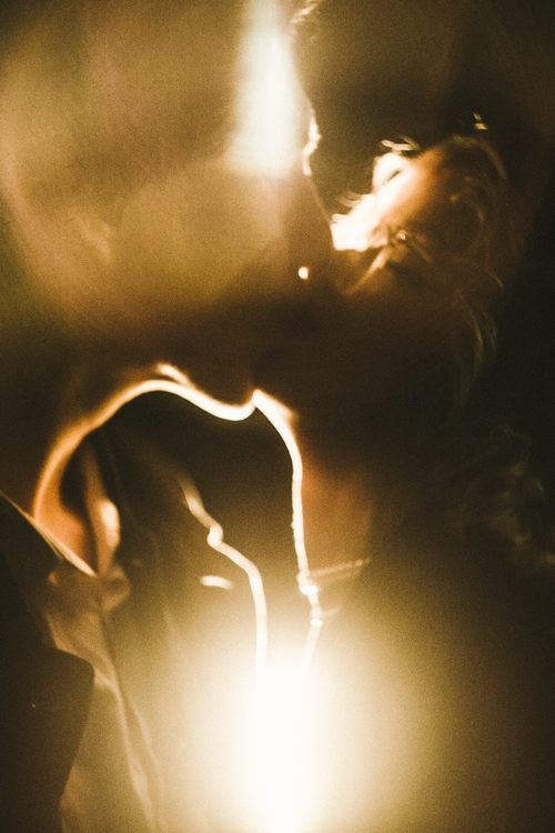 Free A warm, abstract photograph of a couple embracing with golden light and soft focus. Stock Photo