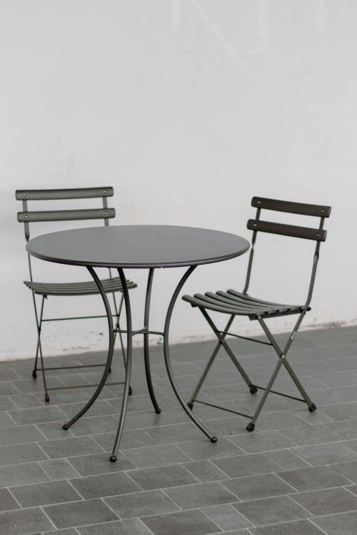 Free Stylish metal table and chairs in minimalist design on tiled floor. Stock Photo