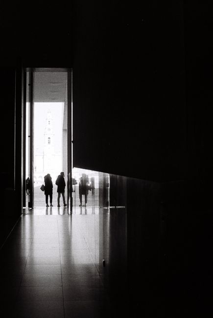 Intriguing silhouettes of people standing in a dimly lit corridor in Fátima, Portugal.