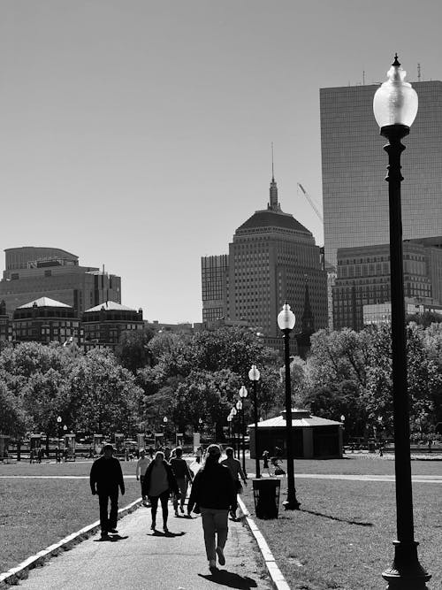 Grayscale Photo of People Walking on the Pathway to the City
