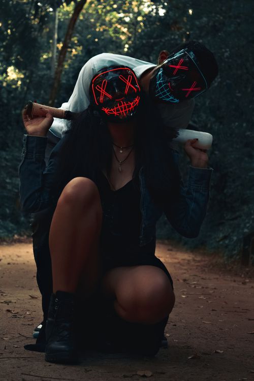 Free Two people in LED masks posing in a spooky forest scene, creating an eerie atmosphere. Stock Photo