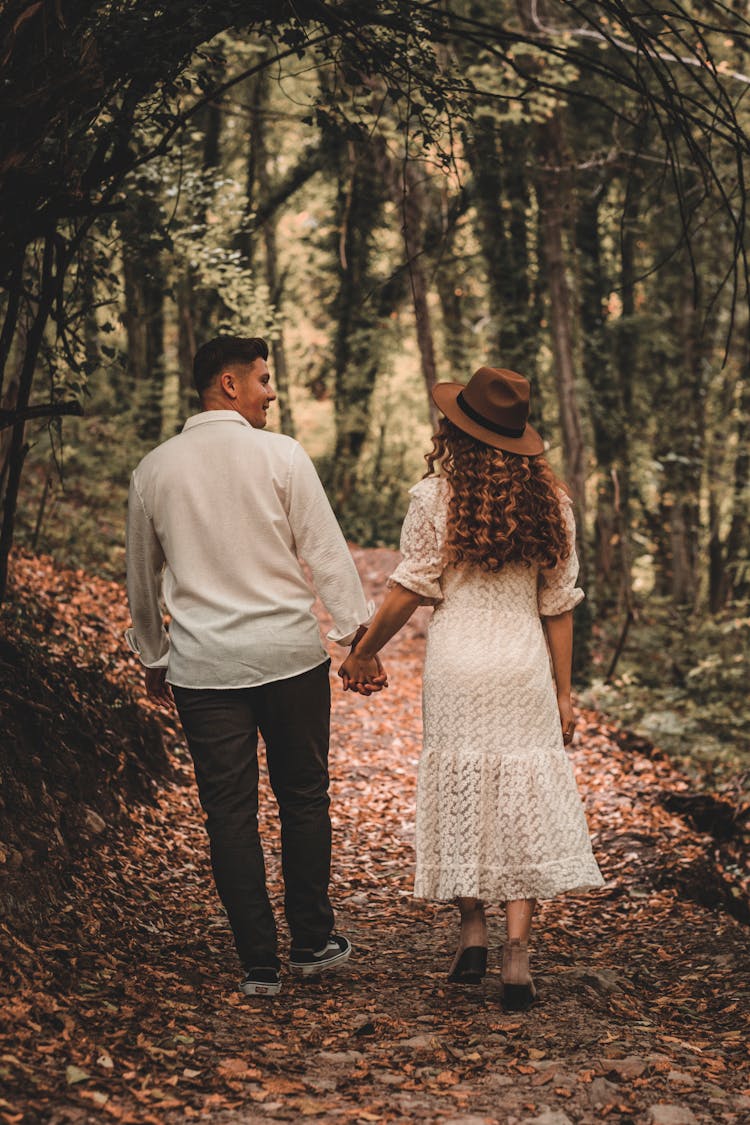 A Man And A Woman Standing Beside The Trees