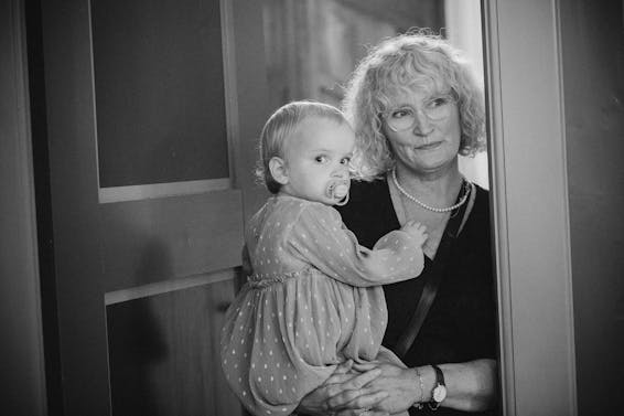 Woman in White Long Sleeve Shirt Carrying Baby in Grayscale Photography