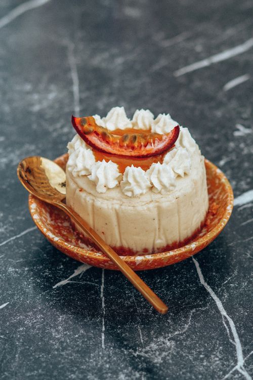 Free Tasty dessert with passion fruit and cream on a decorative plate, perfect for food photography. Stock Photo