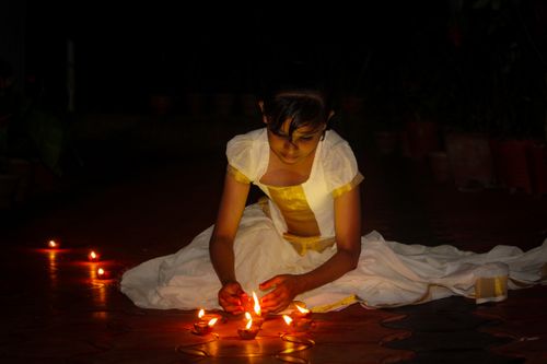 Free A young girl in traditional attire lighting diyas during Diwali night in Madikeri, India. Stock Photo