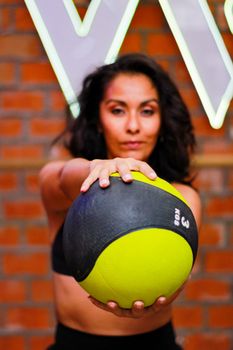 Focused woman working out with a medicine ball, perfect for fitness themes.