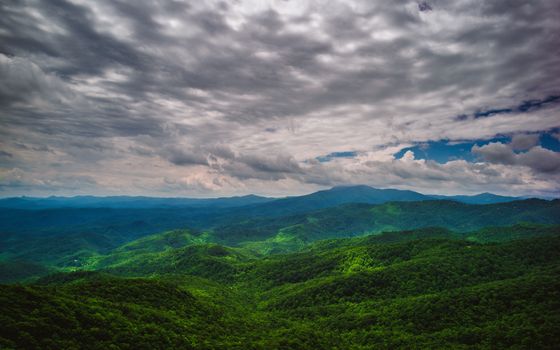 阴沉的天空下，连绵起伏的青山构成了一幅风景优美的山地景观