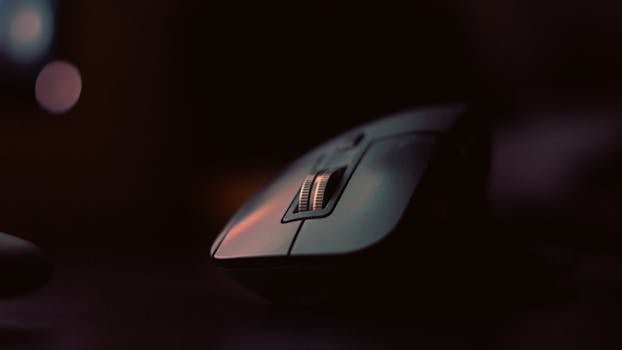 A detailed shot of a wireless computer mouse with dramatic lighting, emphasizing texture and design.