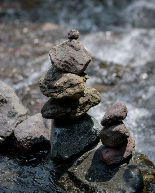 Free Close-up of stacked stones by a stream illustrating natural balance. Stock Photo