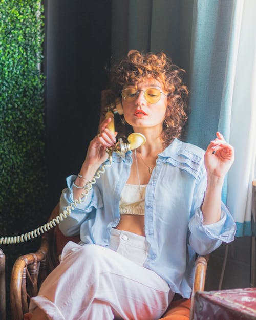 Photo of a Young Woman Talking on an Analog Phone