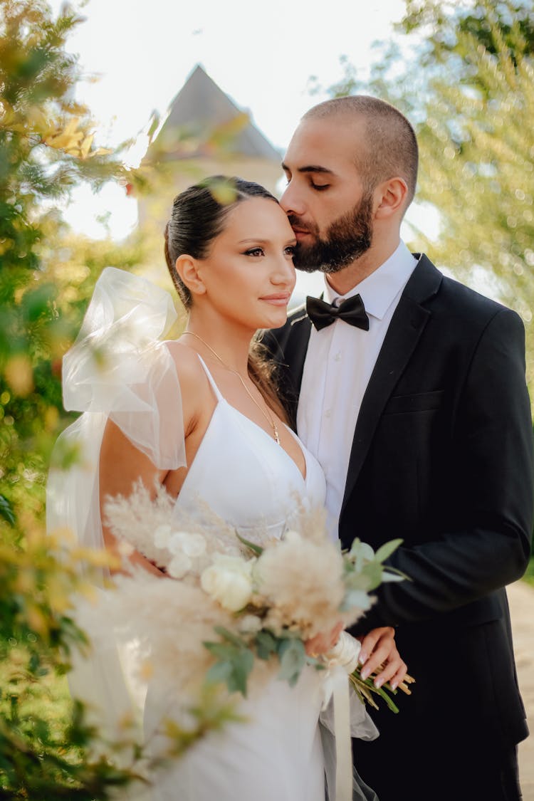 Newlyweds In Suit And Dress Kissing