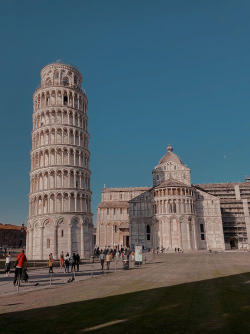 Free Iconic Leaning Tower and Pisa Cathedral under a clear sky in Pisa, Italy. Stock Photo
