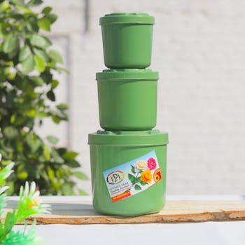 Three green plastic containers stacked outdoors, perfect for kitchen storage solutions.