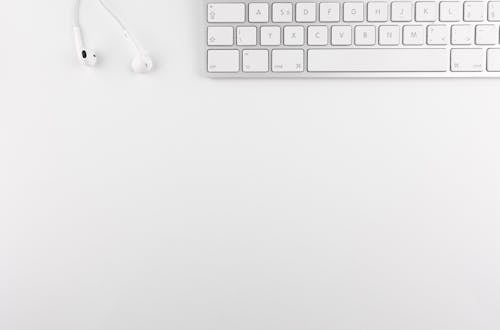 Free Top View Photo of Keyboard Near Earphones Stock Photo