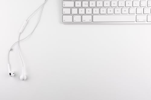 Free Top View Photo of Keyboard Near Earphone Stock Photo