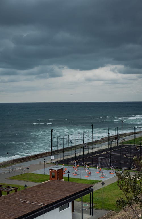 Fotos de stock gratuitas de nubes oscuras, orilla del mar, paseo