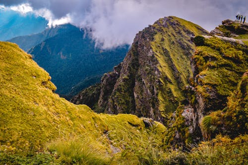 Landscape of Rocky, Green Mountains under a Cloudy Sky 