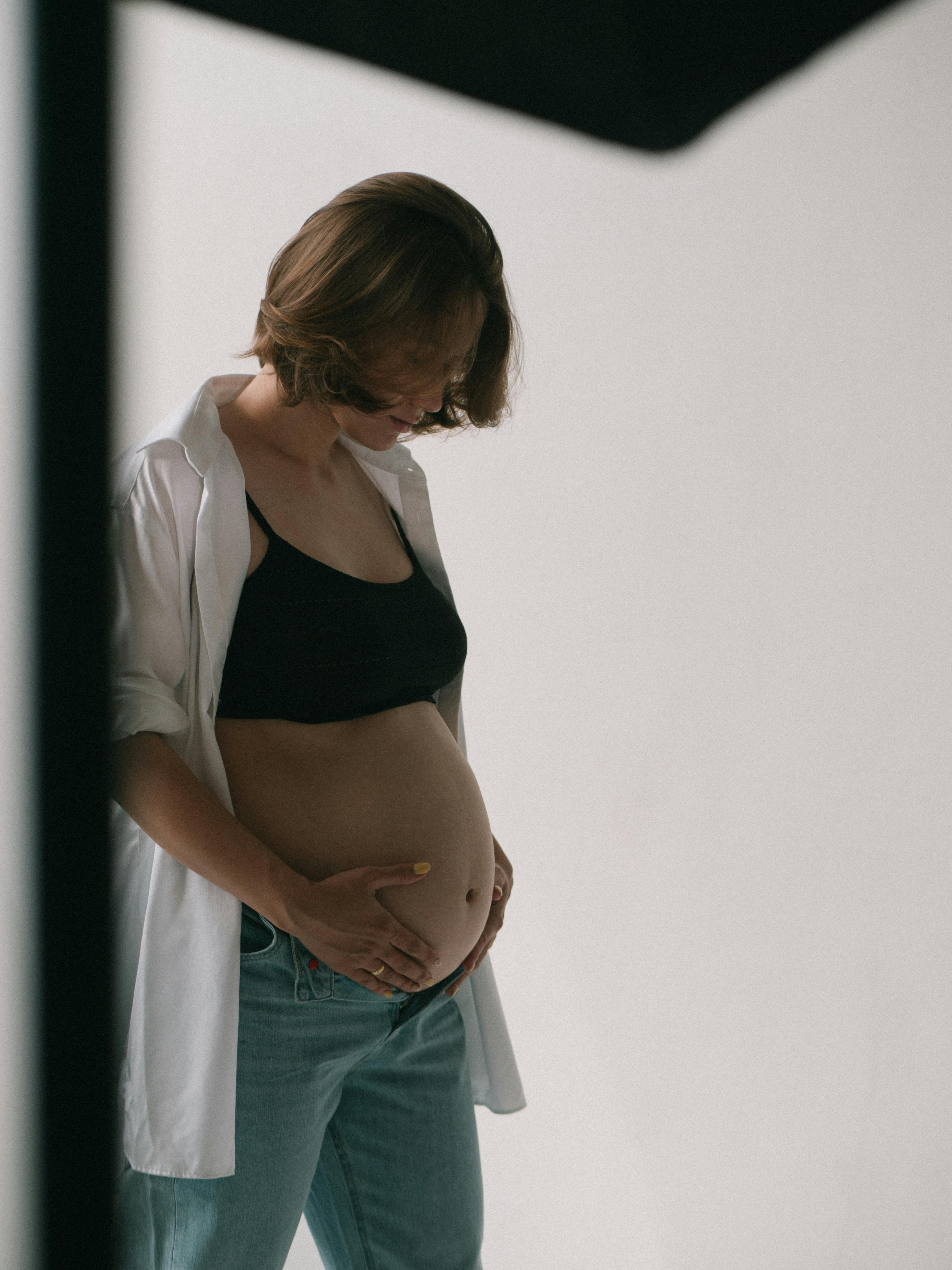 photograph of a pregnant woman touching her belly