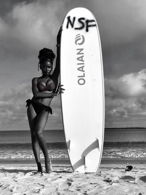 Black and White Photo of a Woman Holding a Surfboard