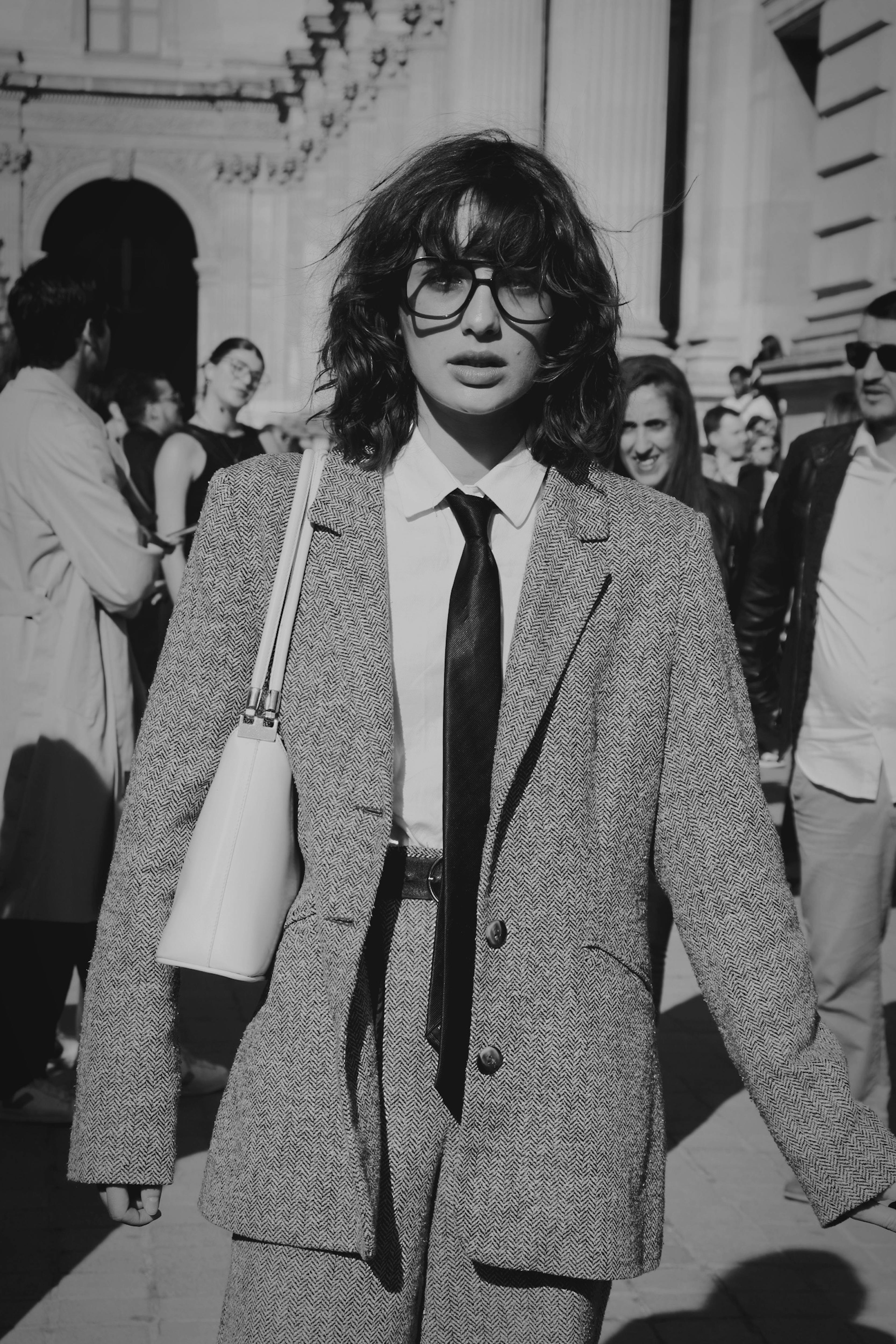 woman in gray blazer standing on street