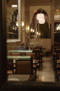Warmly lit restaurant interior with people dining, creating a cozy and inviting atmosphere.