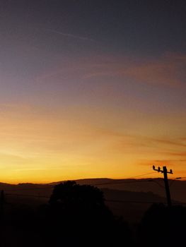 Silhouetted landscape at sunset in Viseu, Portugal with vibrant sky colors.