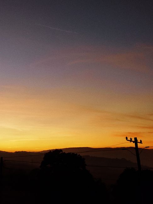 Silhouetted landscape at sunset in Viseu, Portugal with vibrant sky colors.