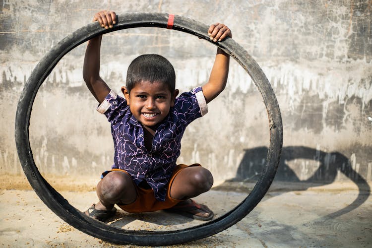 Boy Playing With A Bicycle Tire